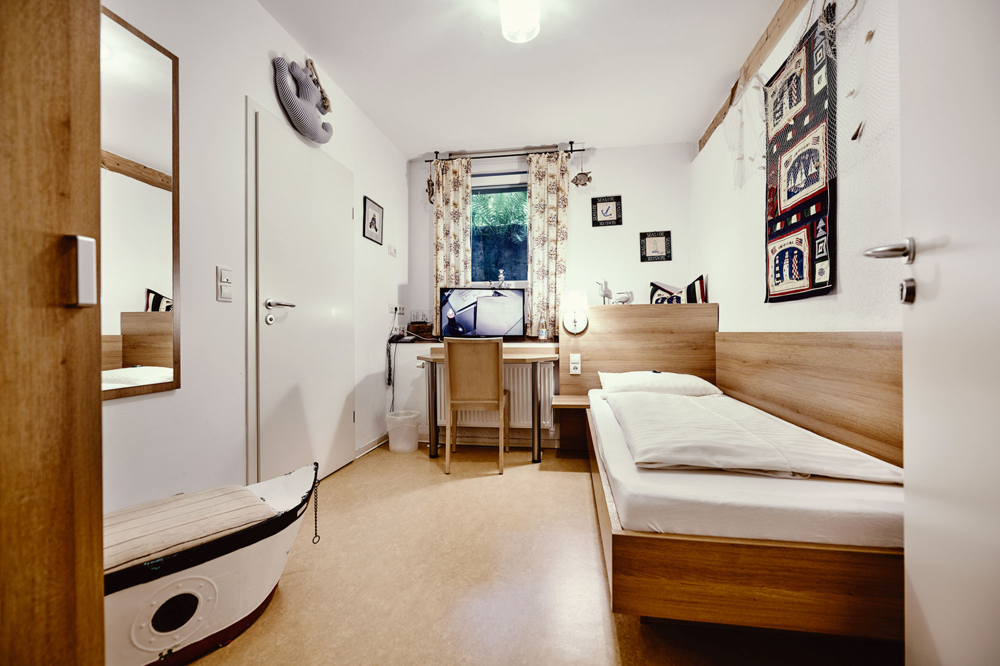 Einzelzimmer mit Schreibtisch und Einzelbett
